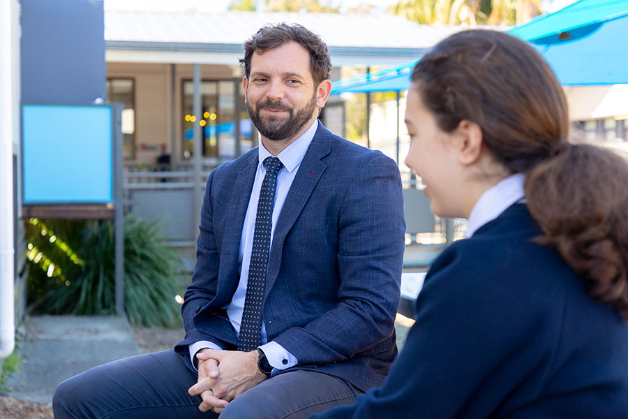 Wellbeing staff meeting with a student outside