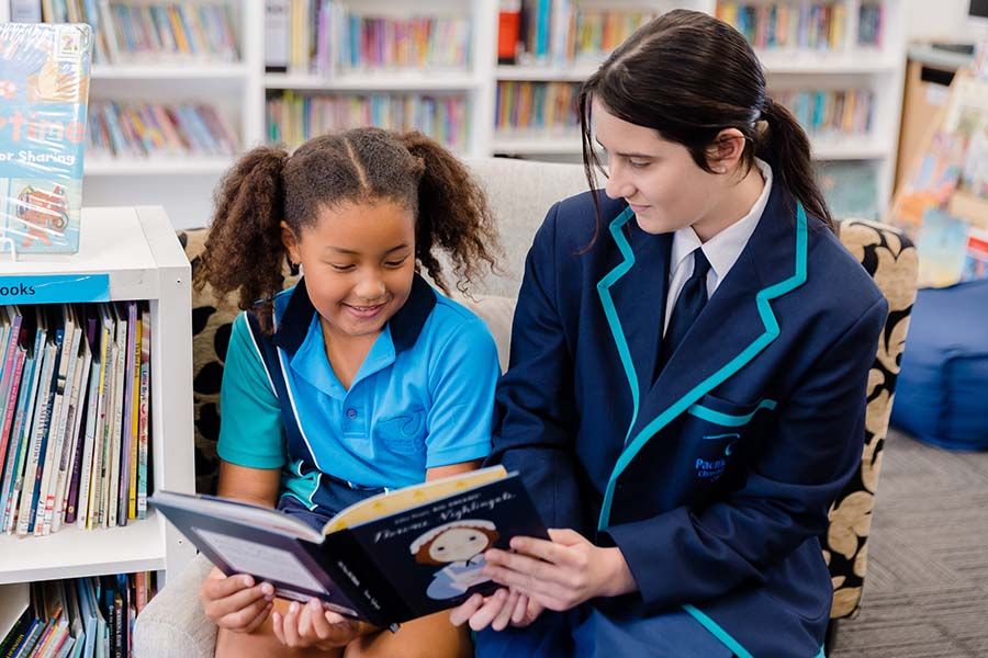 Senior School student reading to a Junior School student